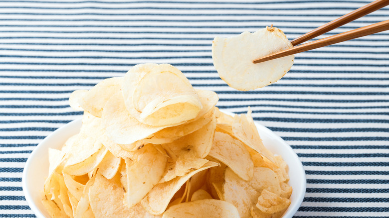 potato chip held by chopsticks