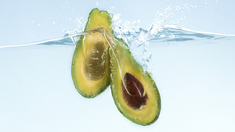 A sliced avocado submerged in water