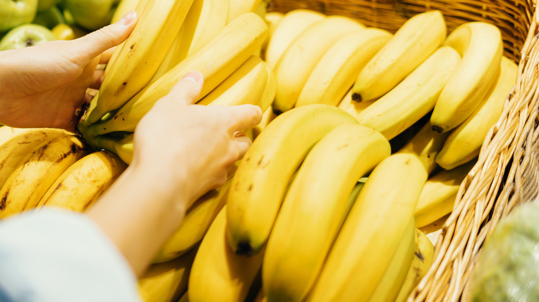 Woman touching bananas at store
