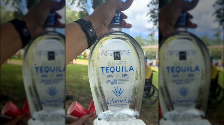 Hand holds Maker's Mark Silver Tequila