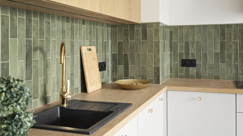 A modern kitchen with green tile-style backsplash