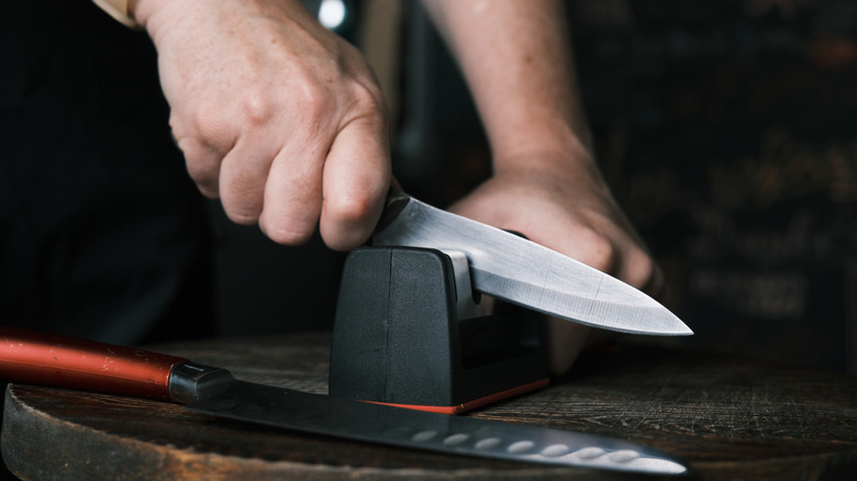 Sharpening a knife with a manual sharpener