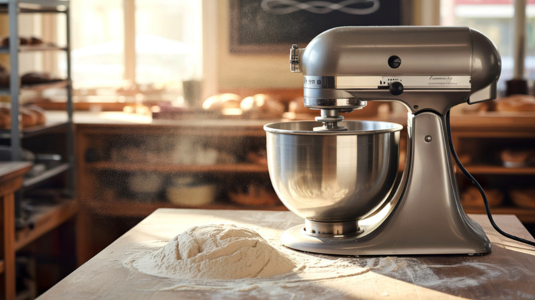 Silver KitchenAid stand mixer by bread dough on bakery table