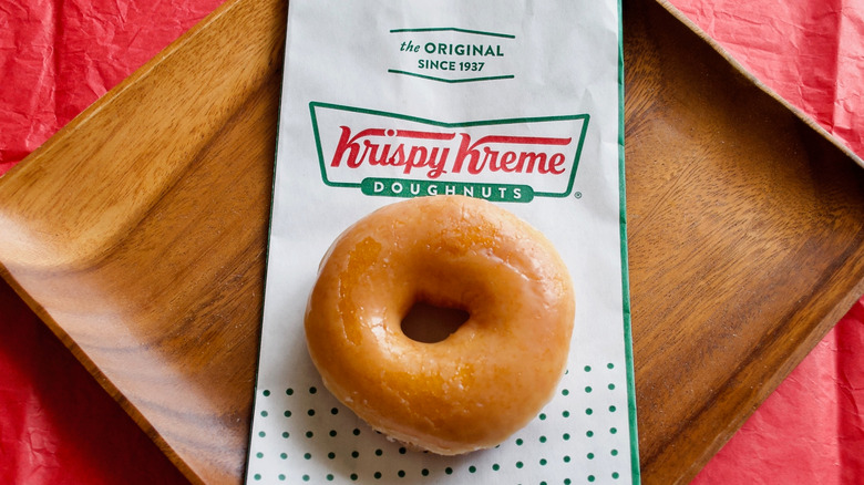 Krispy Kreme donut and bag on a table