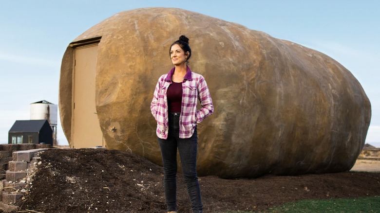 A woman stands in front of a potato hotel