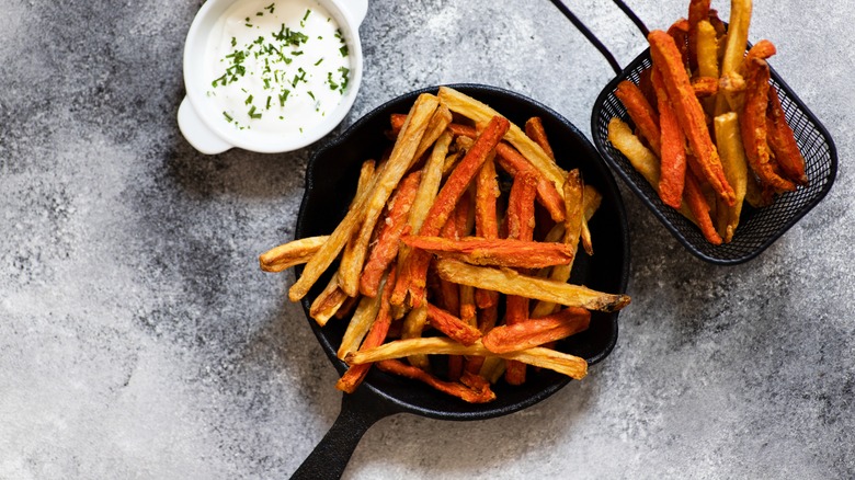 carrot fries in skillet and basket on countertop