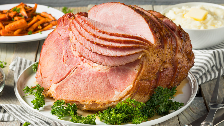 Spiral cut ham with vegetables in background