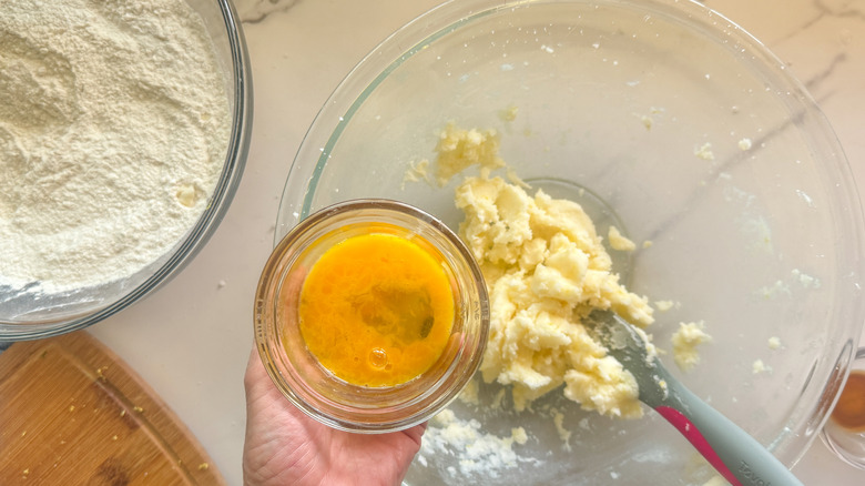 hand adding beaten egg