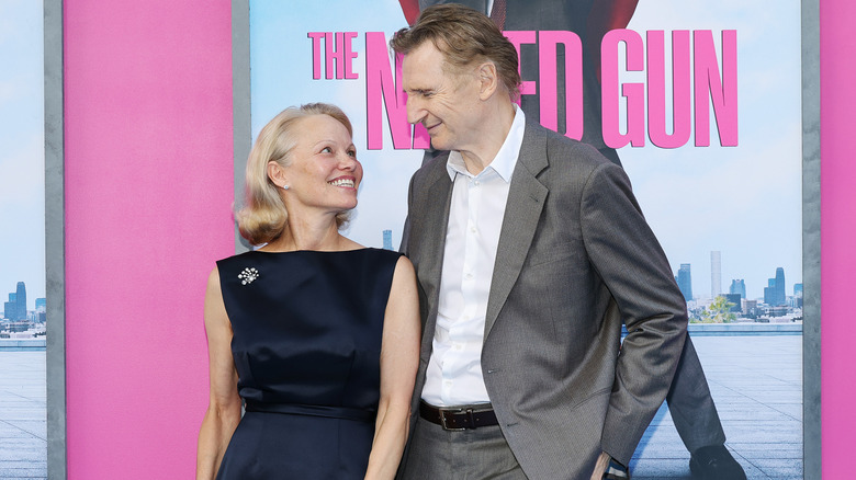 Liam Neeson and Pamela Anderson smile at each other at "The Naked Gun" New York premiere