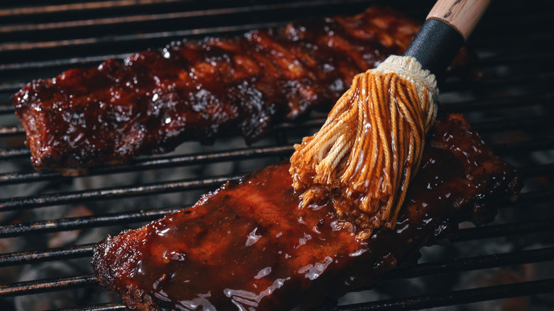 Brushing barbecue sauce on ribs