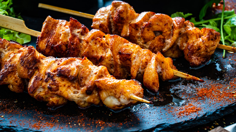 Grilled chicken skewers piled on a plate