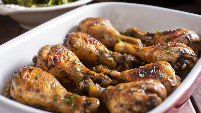 Baked chicken legs in a casserole dish with honey marinade