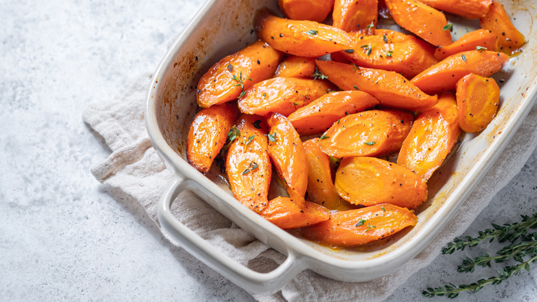 Glazed carrots with herbs in a white casserole dish