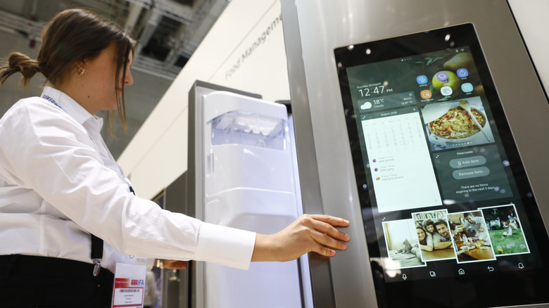 Customer examining smart fridge in store
