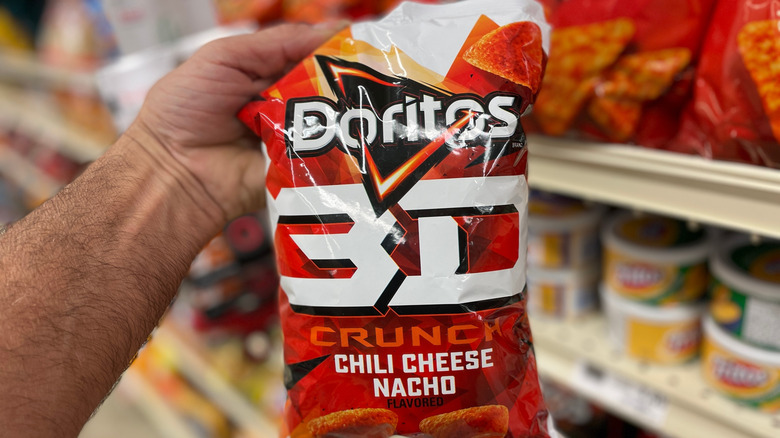 A hand holding a Doritos 3D bag