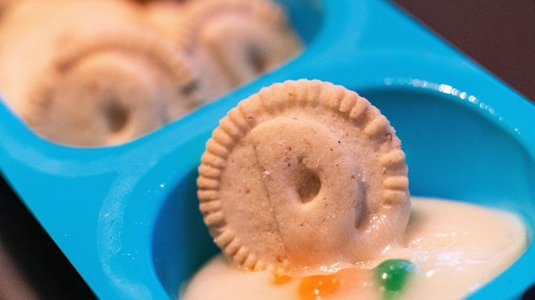 A Dunakroo cookie dipped in frosting in its plastic tray