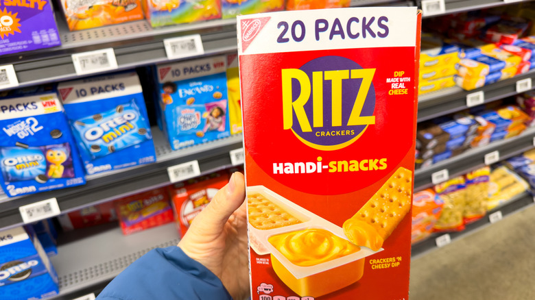 A hand holding a box of Ritz Handi-Snacks