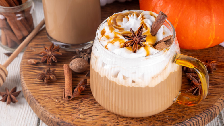 Pumpkin spice latte with cinnamon sticks in glass mug