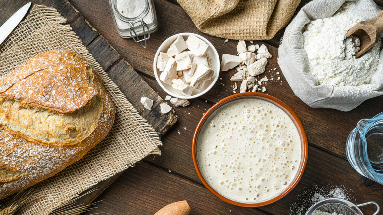 The ingredients needed to make bread are set out on a table.