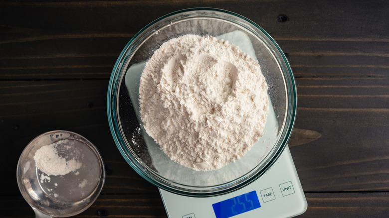 Flour sits in a bowl on top of a scale.