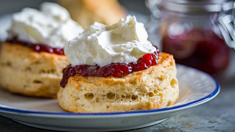 Shortcakes topped with strawberry jam and whipped cream on a plate