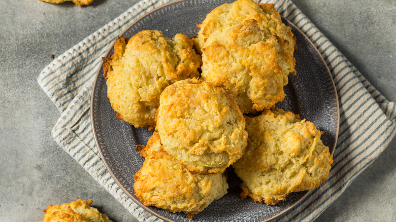 A plate full of drop biscuits on a table