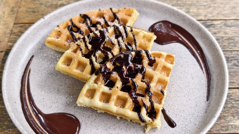 Plate of waffle triangles drizzled with chocolate sauce