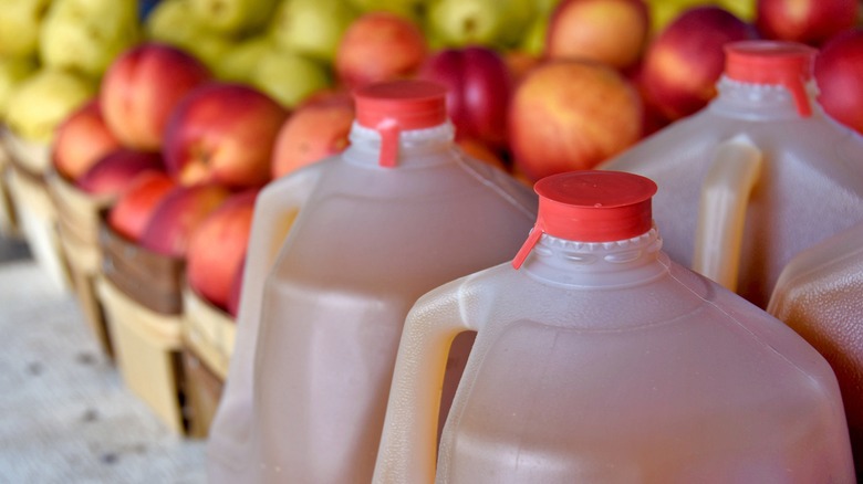 Apple cider jugs with apples in baskets