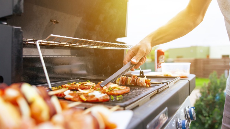 Person flipping meat on a grill