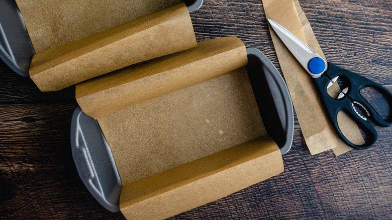 Two loaf pans with parchment paper inside