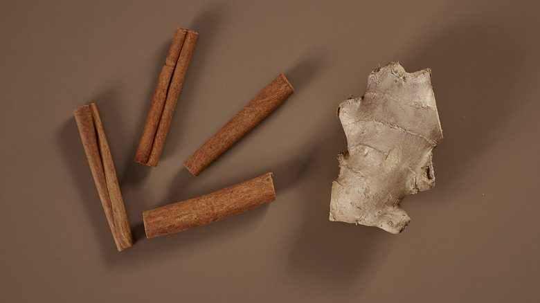 Cinnamon and ginger arranged on a brown background