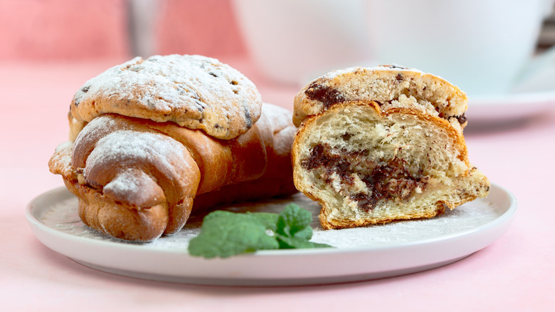 Whole and crosscut cookies on a plate topped with powdered sugar