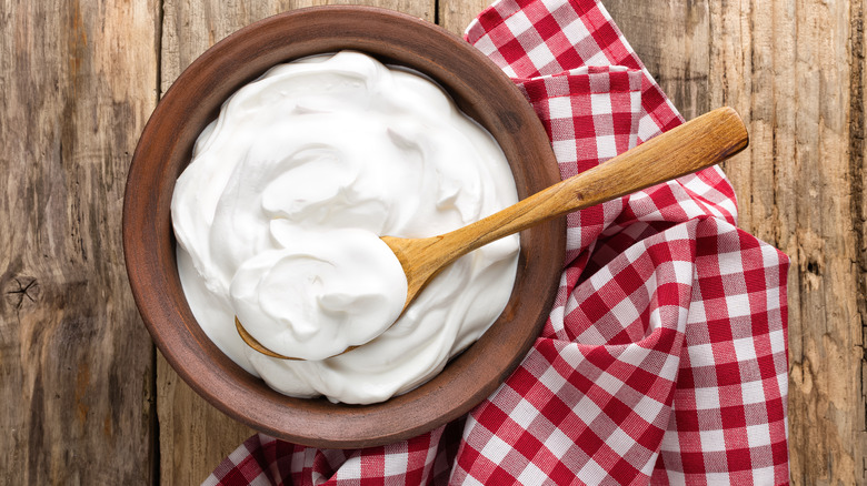 bowl of mayonnaise on wooden table with spoon