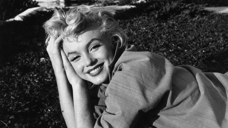 A black and white photo of Marilyn Monroe smiling at the camera