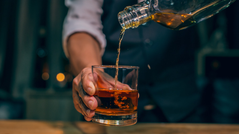 Dark alcohol pouring into glass