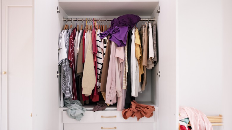 A disorganised closet and some piles of used clothes
