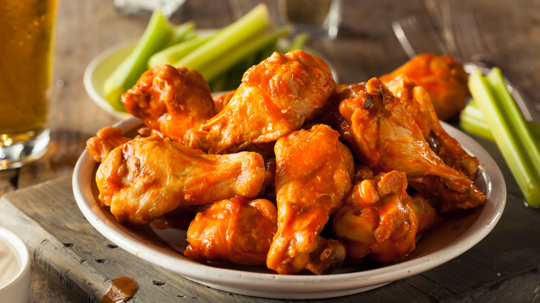 Buffalo wings in bowl with sticks of celery
