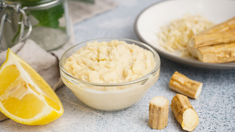 Prepared horseradish in bowl with wedge of lemon
