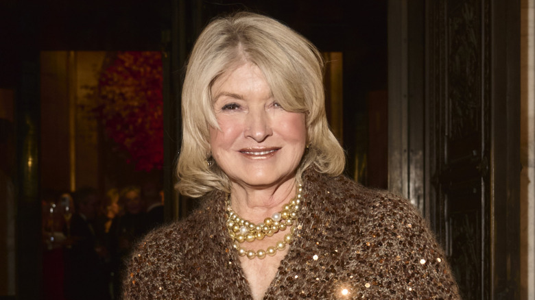 Martha Stewart wearing a sparkling brown top and pearls smiling at event