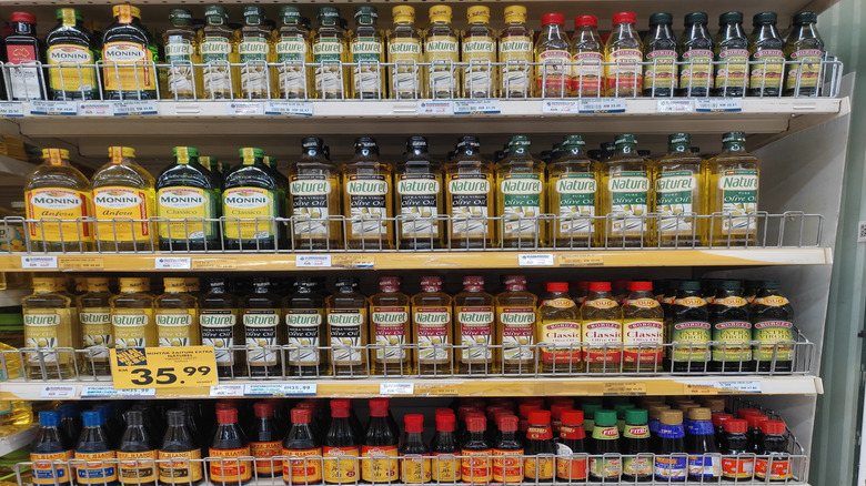 Different types of olive oil bottles on grocery store shelves