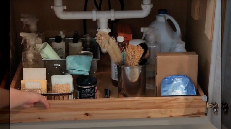 A pull-out tray under a kitchen sink