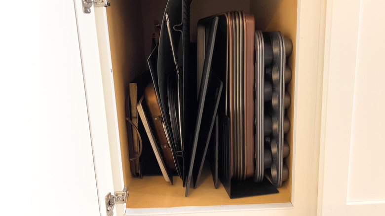 Trays stacked in a cupboard using tray dividers