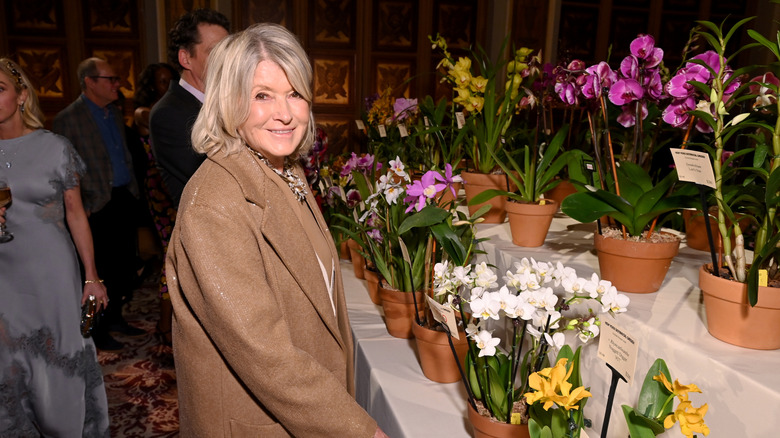 Martha Stewart in front of flowers in pots