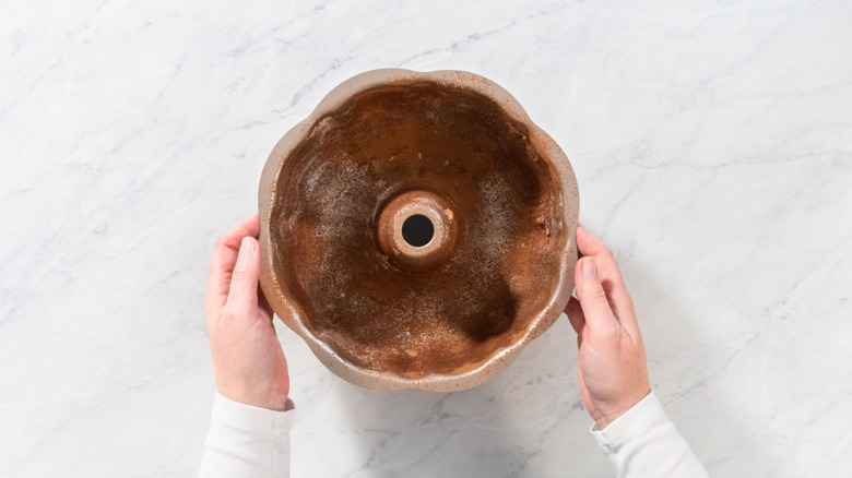 High angle view of a bundt cake pan dusted with cocoa powder