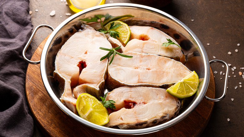 Catfish steaks in pan with lime and herbs