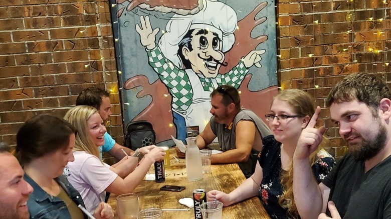 Seven sitting at a table enjoying beverages as Ledo's Pizza