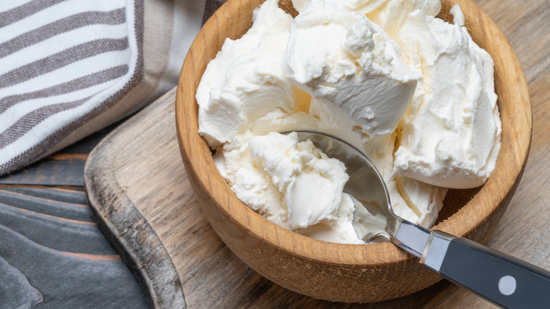 Traditional mascarpone cheese in wooden bowl