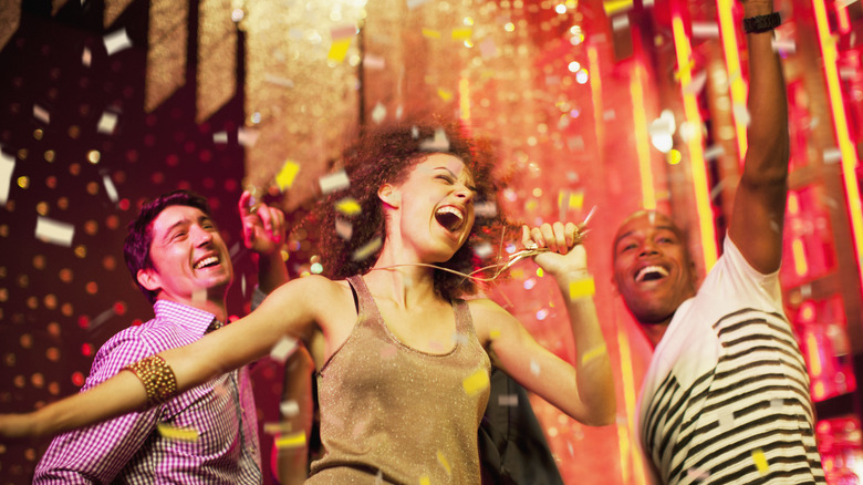 Trio dancing and smiling at club