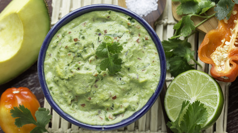 Creamy guacamole surrounded by ingredients