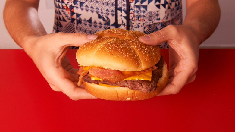 Hands holding cheeseburger